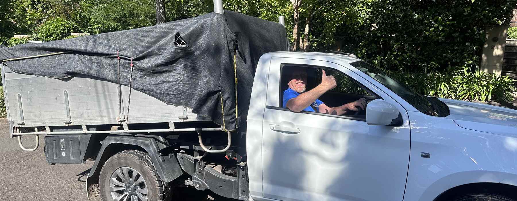Driver in the cab, leafy street