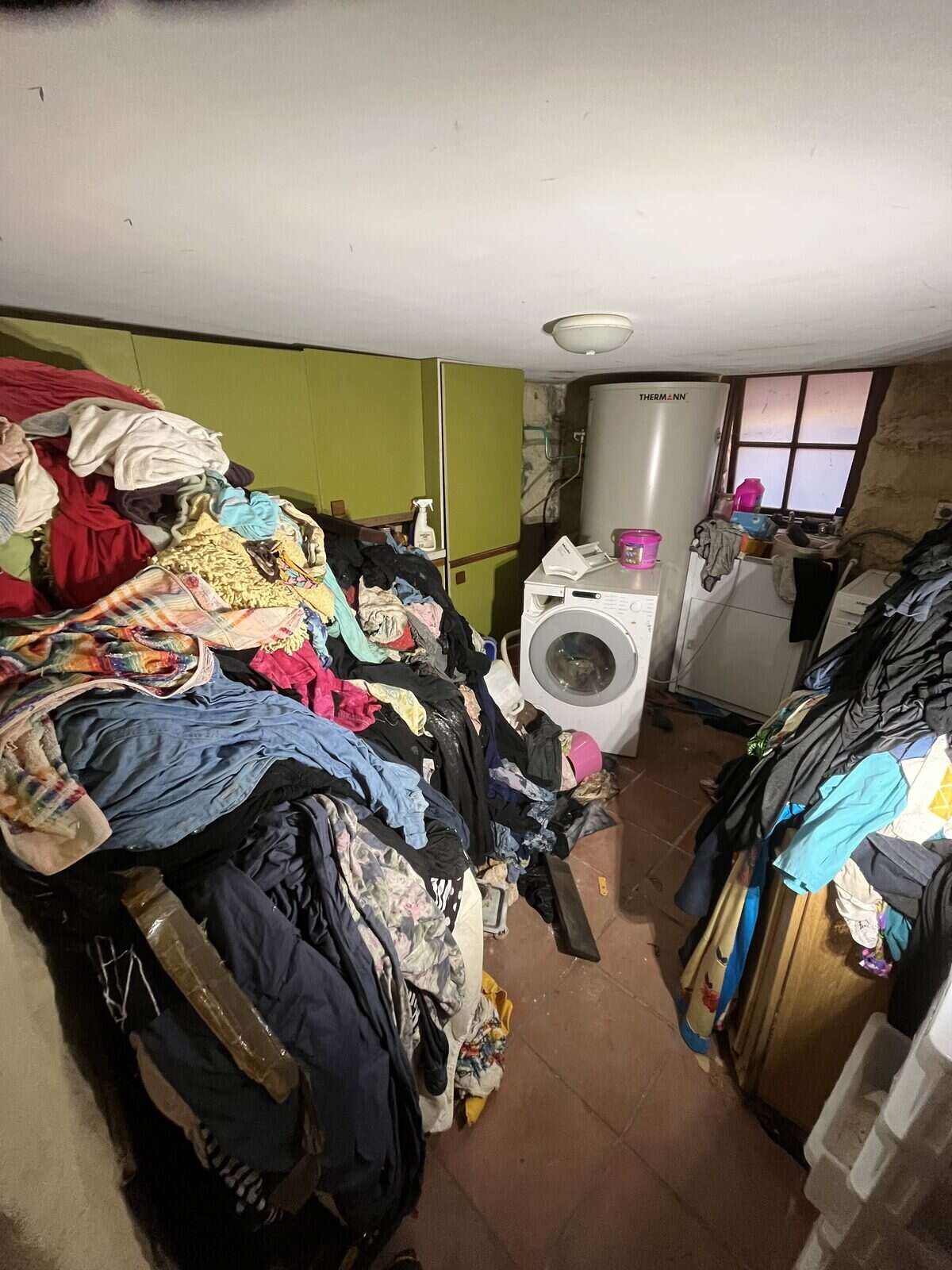 A heavily packed room before a hoarding clearout, floor to ceiling with belongings