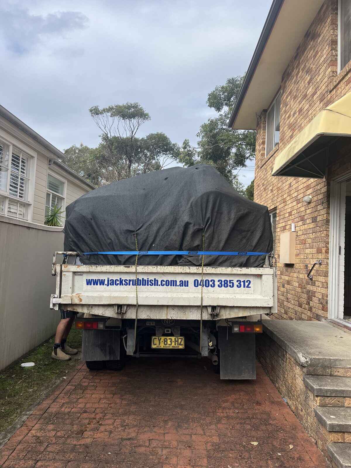 A Jack's truck loaded with a full household rubbish load in a driveway