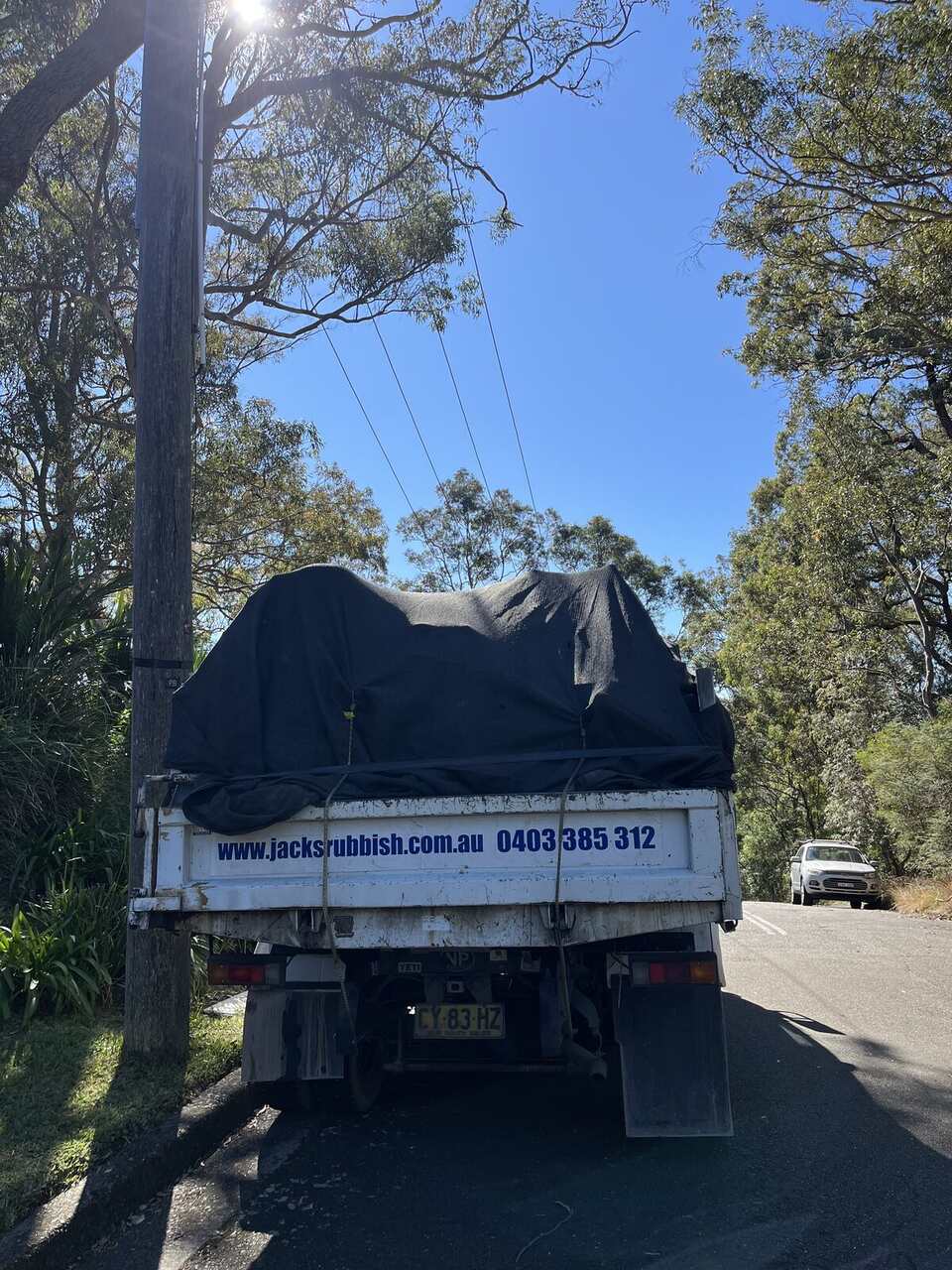 The rear of a Jack's Rubbish truck loaded and ready to pull away on a same-day pickup