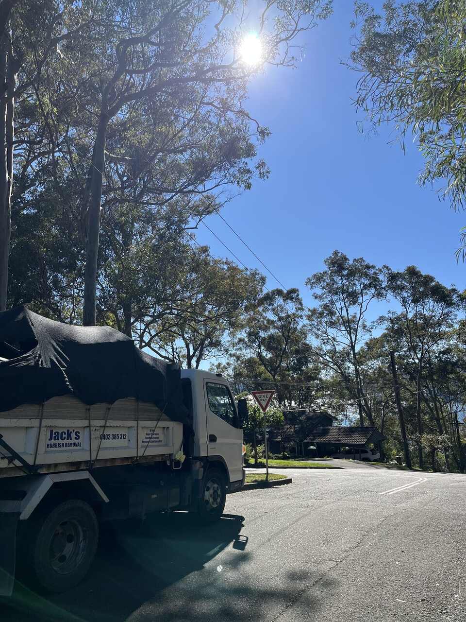 A Jack's Rubbish truck parked on a quiet North Shore street